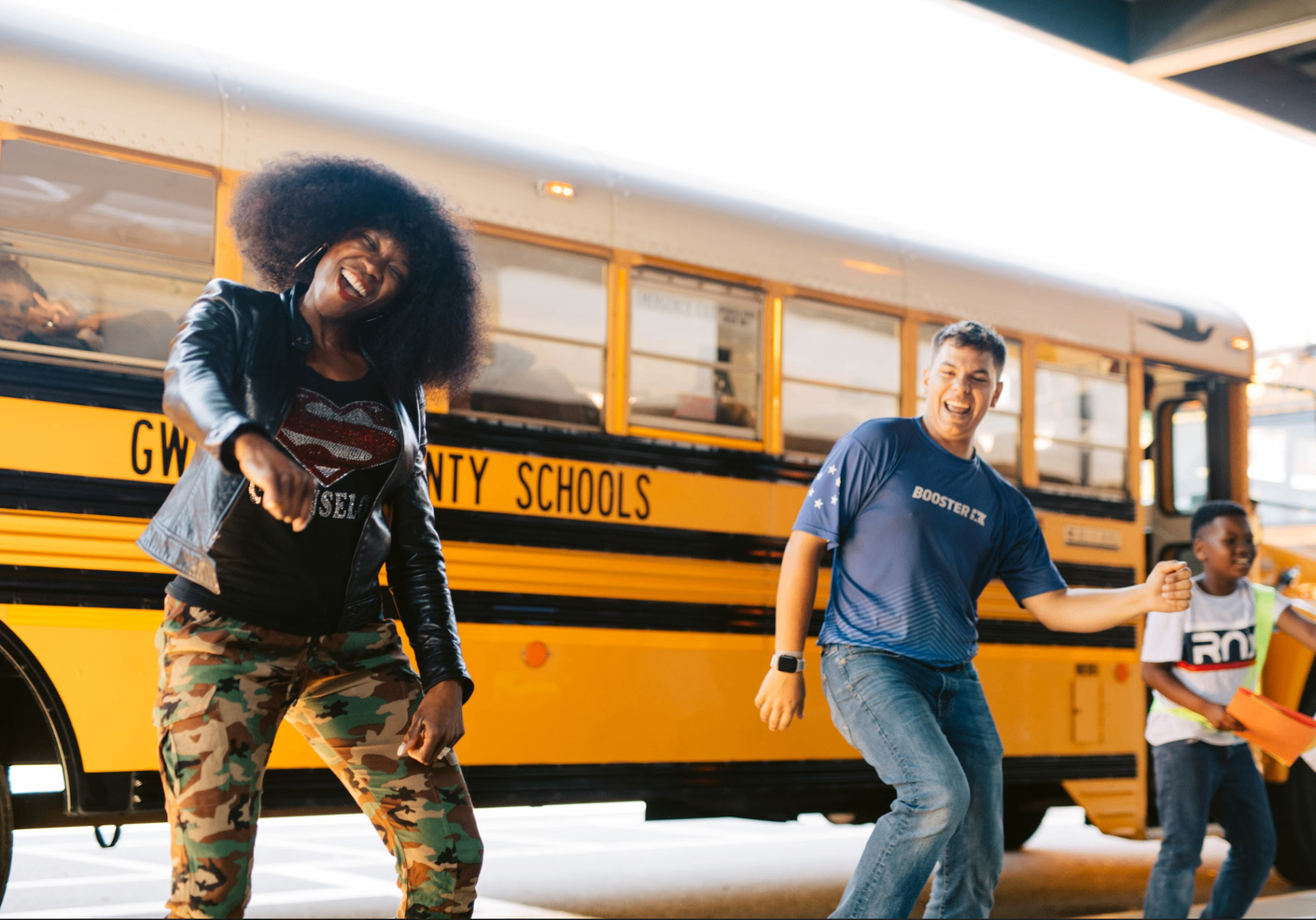 Booster ambassador dancing with students at school dropoff